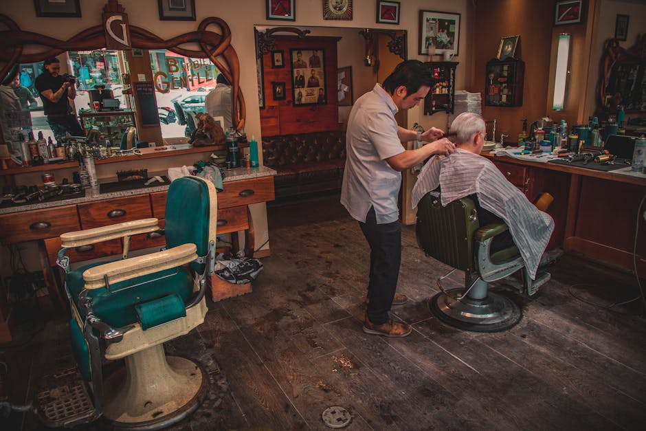 A barber cutting a client's hair at a traditional barbershop in Japan