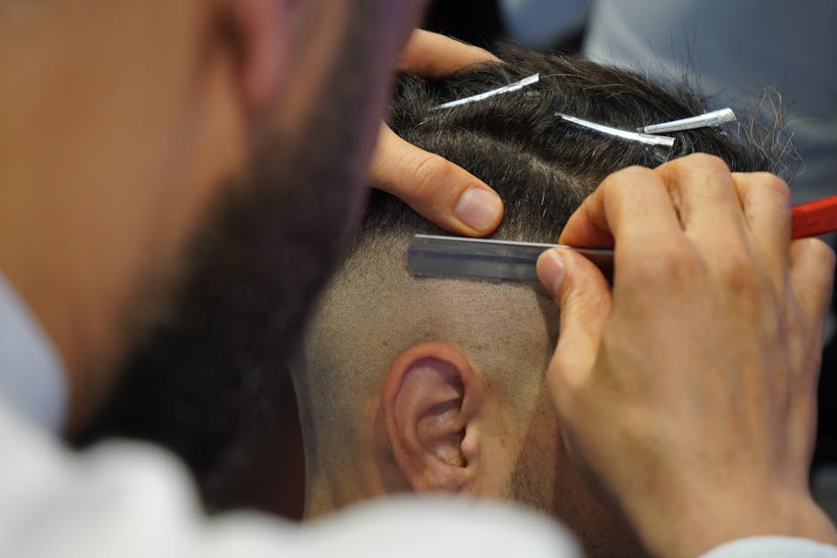 A barber using clippers to create an undercut hairstyle